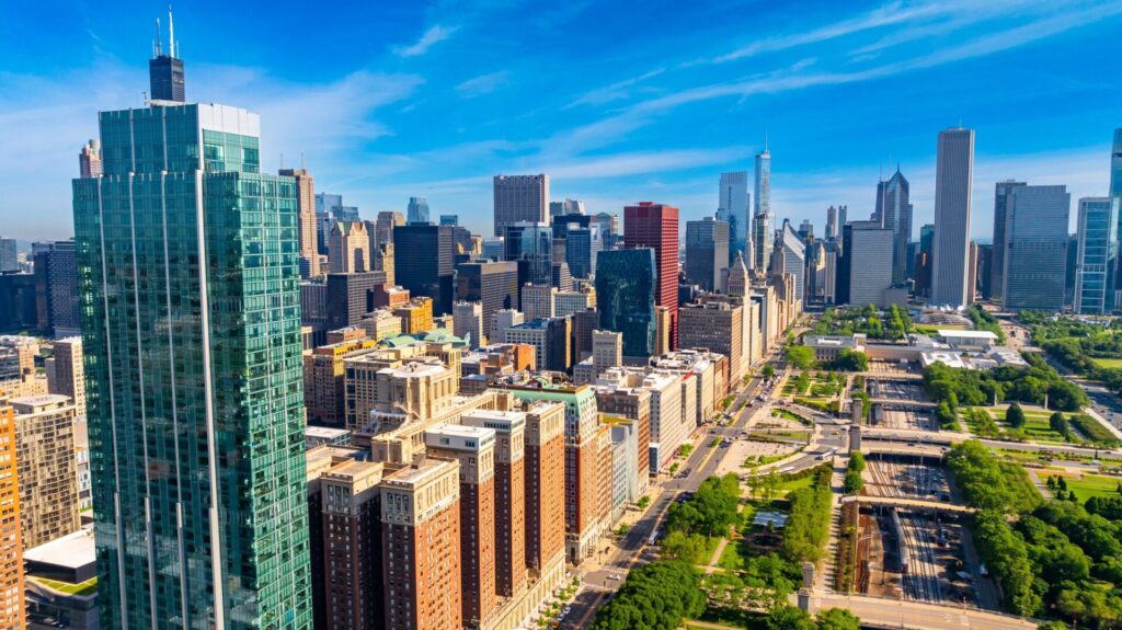 Aerial view of downtown Chicago with skyscrapers and green spaces.