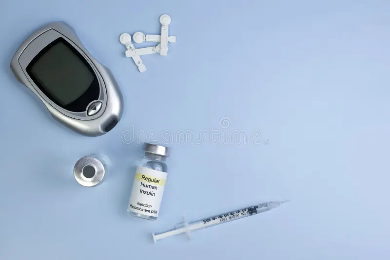 Blood glucose meter, insulin vial, syringe, and lancets on a light blue background.