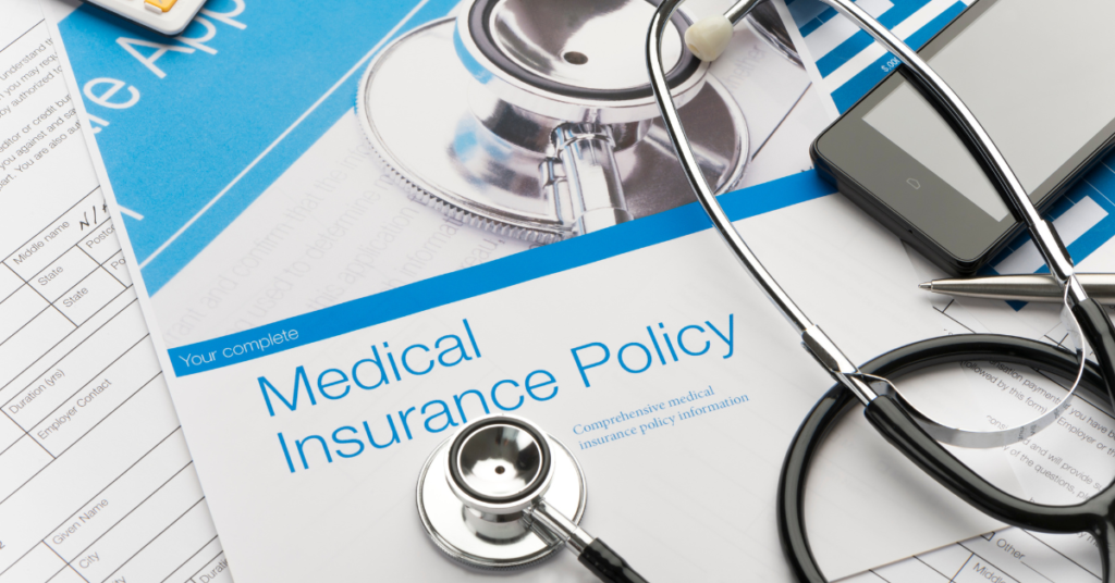 Medical insurance policy document with a stethoscope, smartphone, and paperwork.