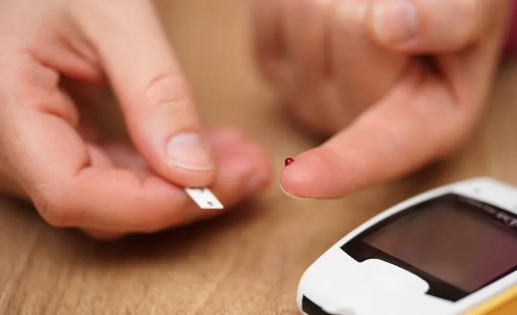 A person testing their blood sugar using a glucose meter.